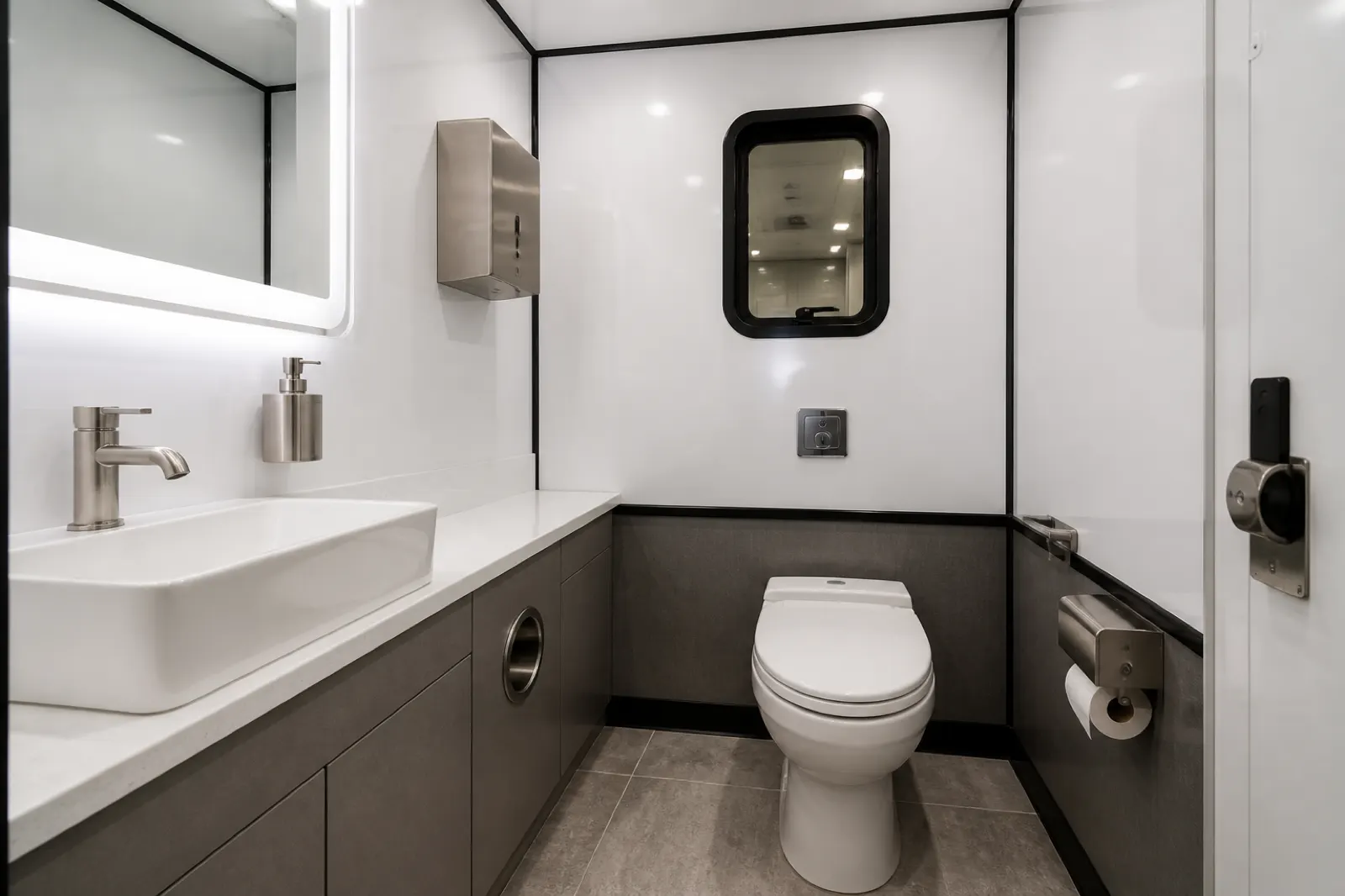 Clean VIP mobile restroom interior with sink and mirror lighting
